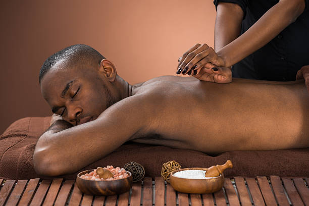 Young African Man Getting Massage In Spa Young African Man Getting Massage In Spa